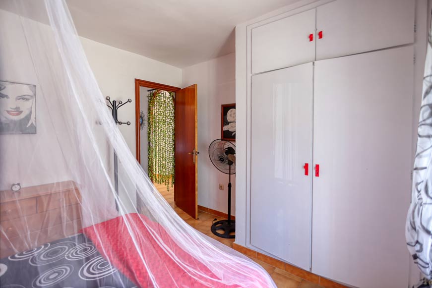 Armario blanco en dormitorio principal visto desde la cama