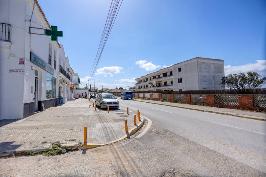 Acera amplia con farmacia y coches estacionados en avenida trafalgar
