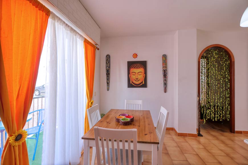 Comedor con mesa de madera y cortinas naranjas decorativas