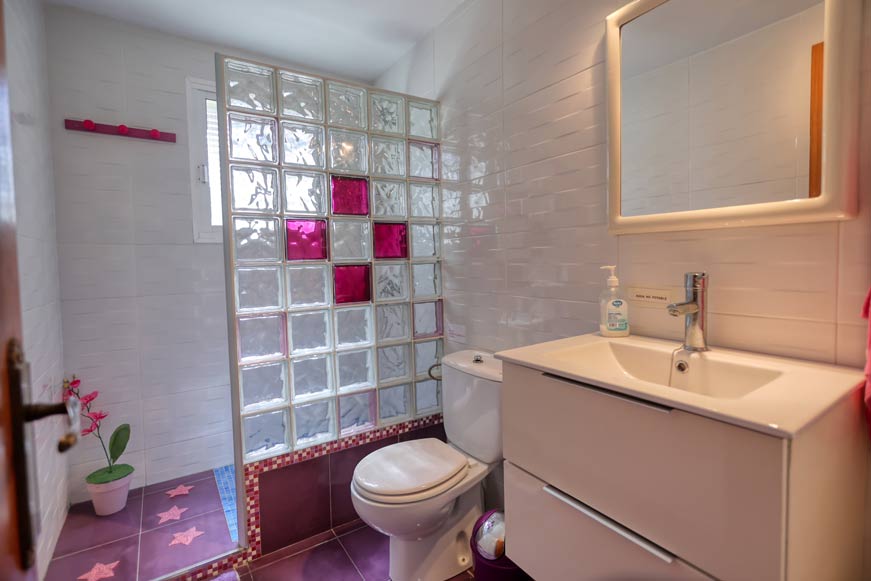 Cuarto de baño moderno con ducha y mampara de bloques de vidrio