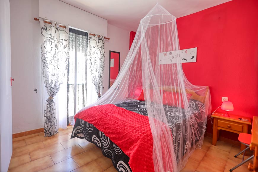 Dormitorio principal con cama doble y mosquitera decorativa