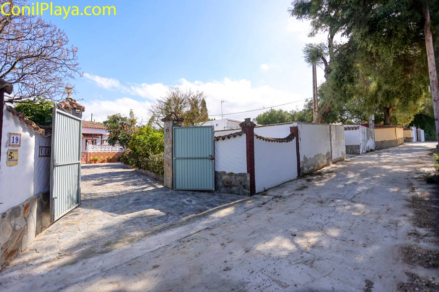 Entrada y zona de aparcamiento junto a vivienda con portón abierto