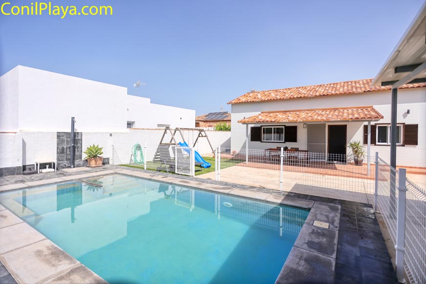 Vista de la piscina protegida junto a la casa desde una esquina