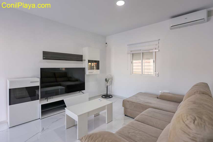 salon con sofá y mueble de televisión