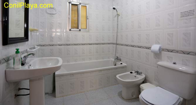 baño con bañera, lavabo, bidé y ventana.