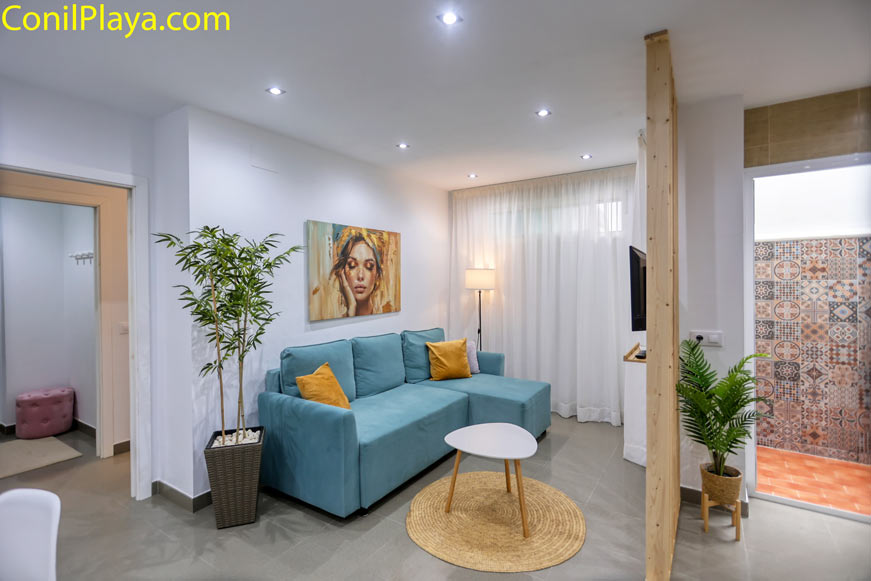 Salón luminoso con sofá azul y decoración moderna, ambiente acogedor