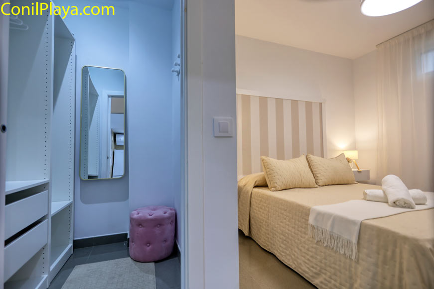 Dormitorio con cama doble, armario vestidor y luz cálida acogedora en apartamento para alquiler en Conil