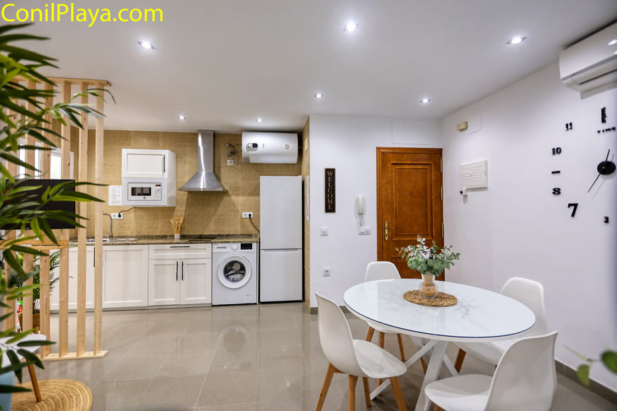 Cocina moderna abierta con electrodomésticos y mesa de comedor pequeña