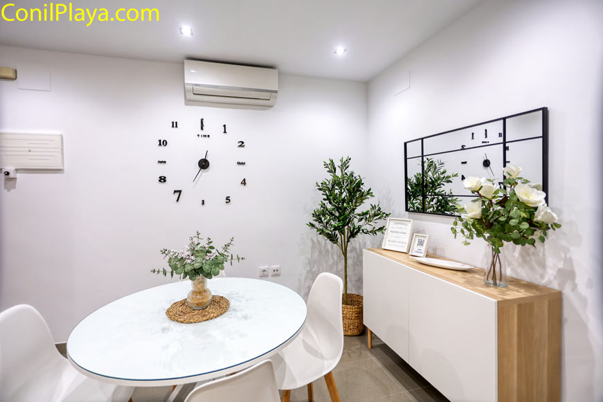 Comedor con aire acondicionado, mesa blanca redonda para 2 comensales y decoración de plantas naturales