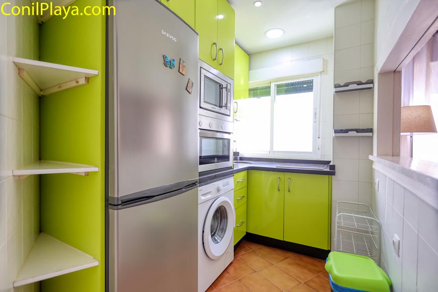 Cocina moderna pequeña con muebles verdes y electrodomésticos integrados