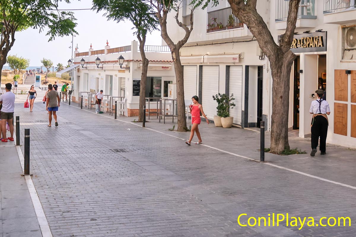 Calle peatonal y personas caminando hacia la playa de los Bateles