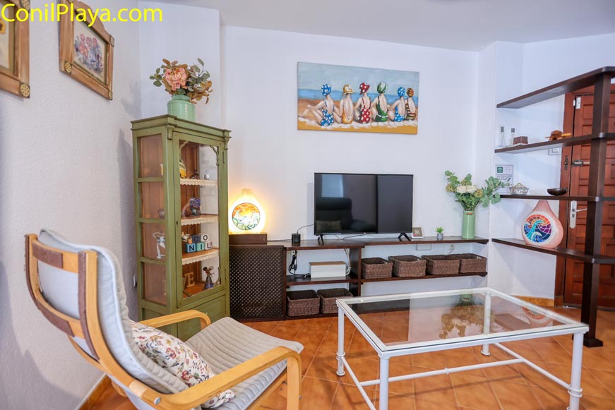 Salón acogedor con televisión y decoración colorida visto desde una esquina