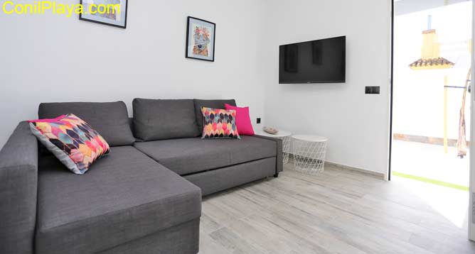 salon con sofá y television plana
