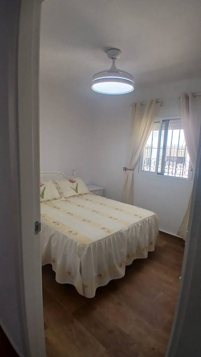 Dormitorio con lampara con ventilador de techo