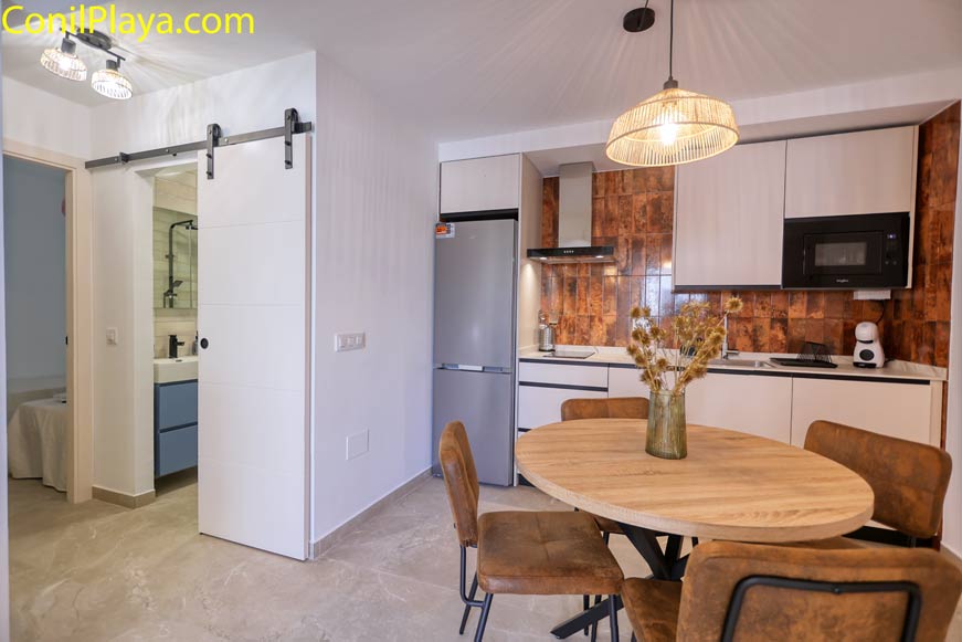 Cocina moderna con mesa redonda y decoración en tonos marrones vista desde la entrada