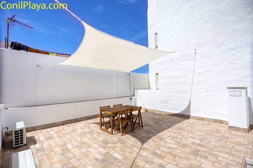 Vista de la terraza con mesa y sillas bajo toldo desde la entrada