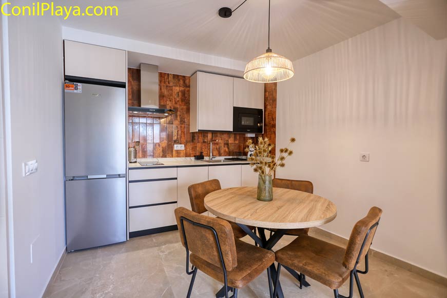 Cocina moderna con mesa redonda y cuatro sillas vista desde la entrada