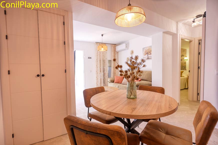 Comedor con mesa redonda de madera y sillas tapizadas vistas al salón