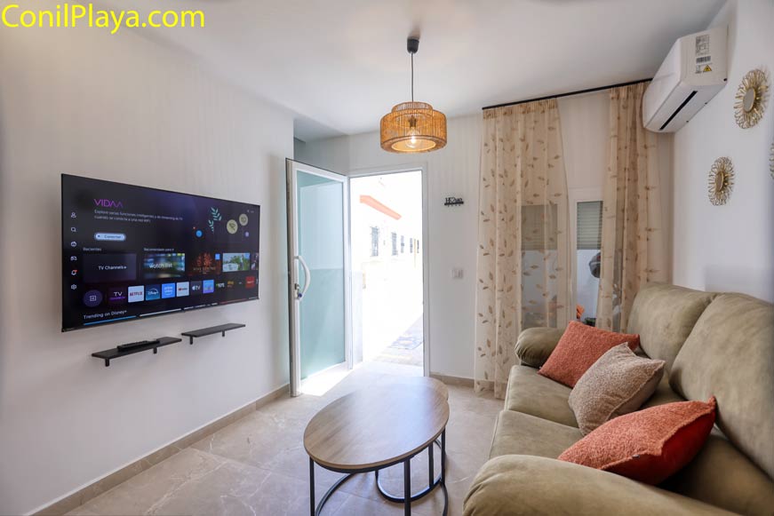 Salón moderno con sofá, televisión en pared y mesa de centro