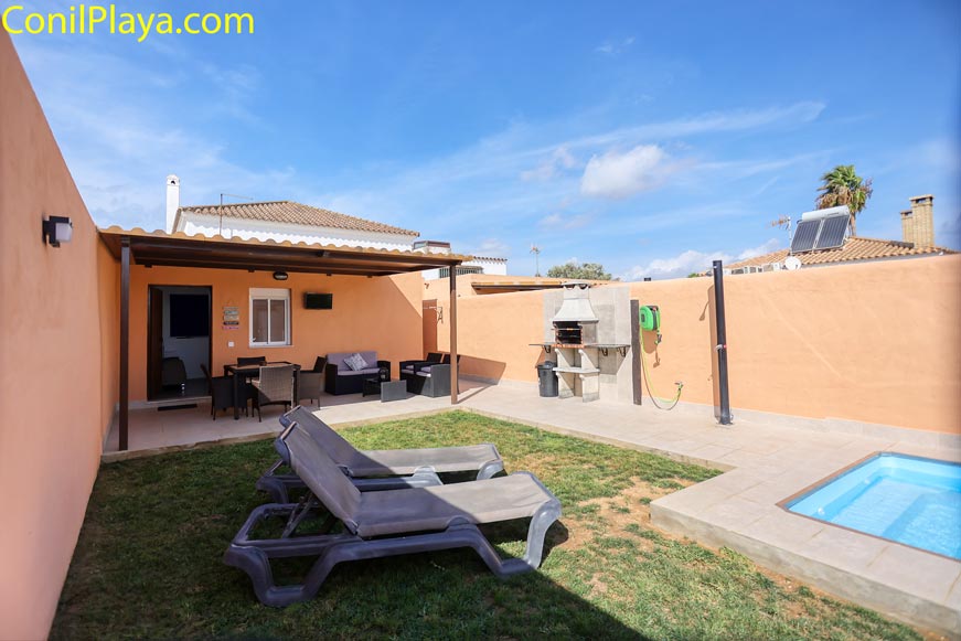 Jardín privado con césped, tumbonas, barbacoa y piscina pequeña junto a terraza