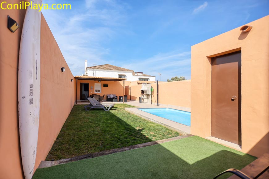 Vista desde la entrada de la casa con piscina privada, césped natural y barbacoa