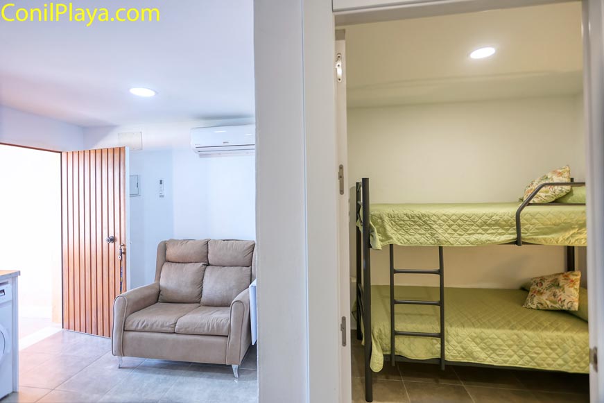 Salón y dormitorio interior con literas visto desde el pasillo