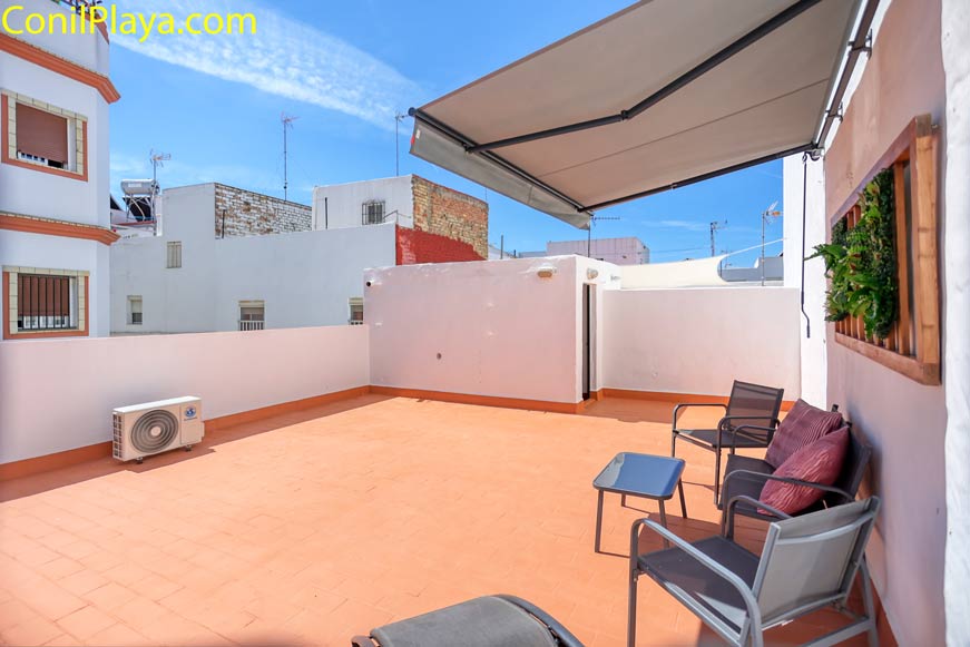 Terraza amplia con sillones, mesa y toldo