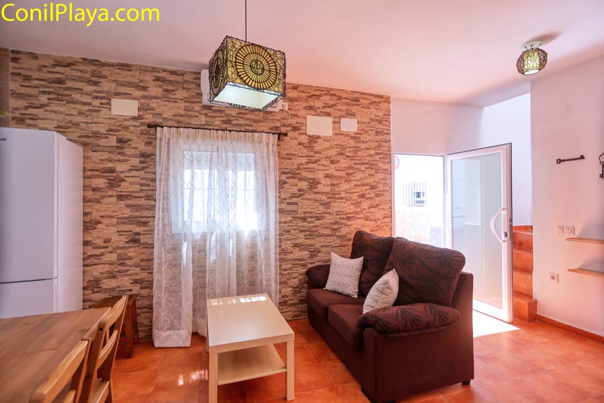 Salón con sofá marrón y mesa de centro junto a ventana