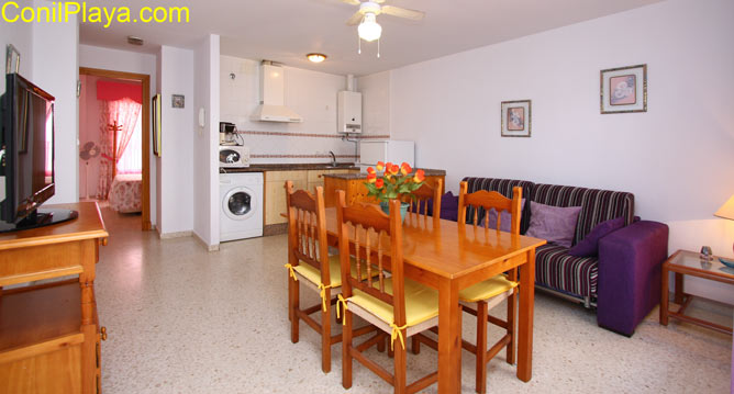 Salón del apartamento con sofá y mesa comedor.