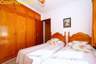 dormitorio con 2 camas individuales y armarios