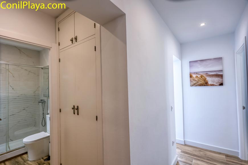 Vista de baño moderno y armario empotrado desde pasillo interior