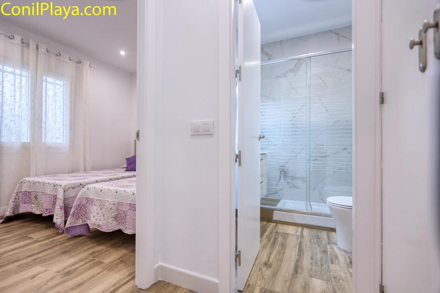 Vista desde el pasillo hacia el baño con ducha y dormitorio