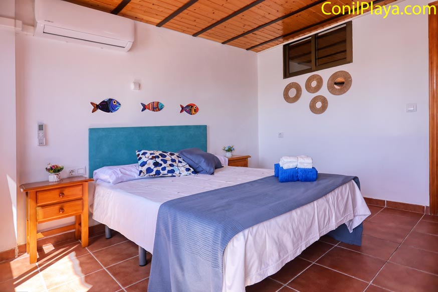 Aire acondicionado en dormitorio con cama doble decorado con detalles marinos