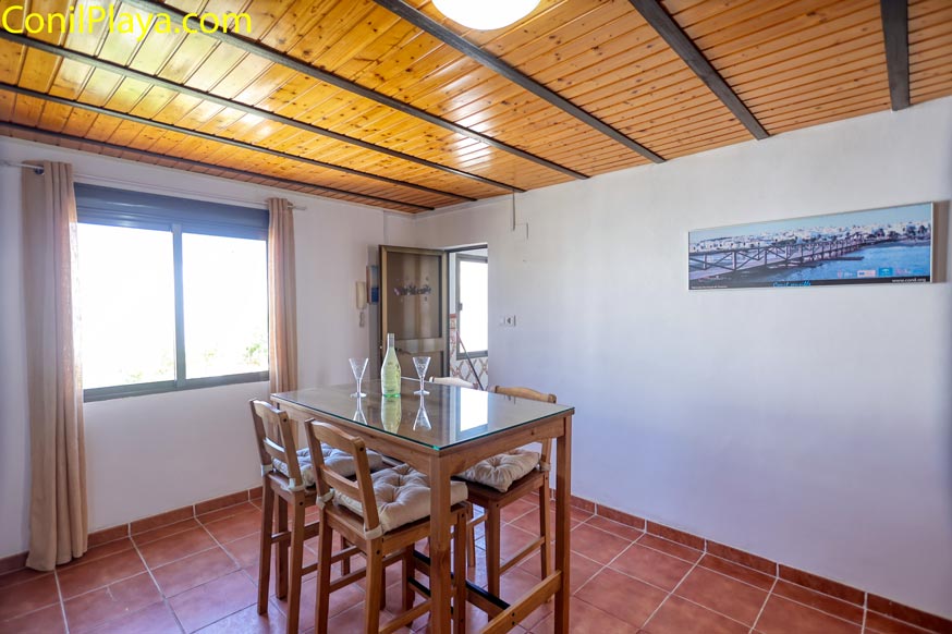 Comedor con mesa alta y sillas junto a ventana grande