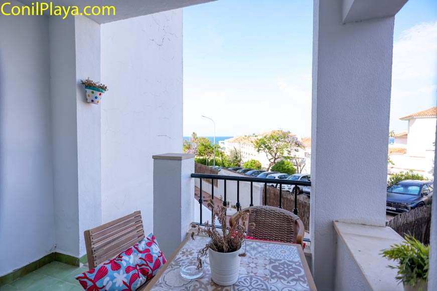 Terraza de apartamento con mesa y sillas vista parcialmente al mar