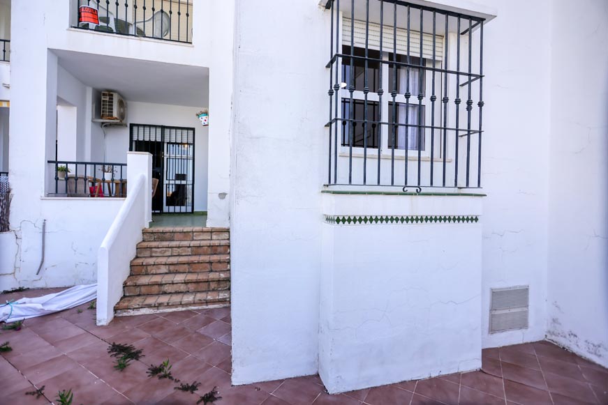 Terraza exterior de apartamento con escalera y acceso a la vivienda visible