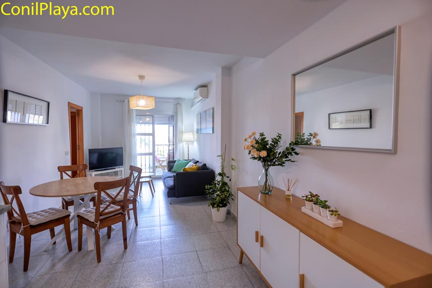 Comedor con mesa redonda y aparador de madera junto a salón