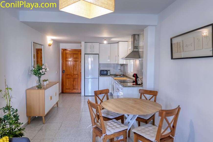 Comedor con mesa redonda y sillas junto a cocina abierta moderna