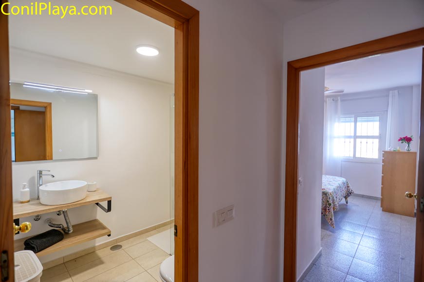 Pasillo con acceso a un baño moderno y dormitorio principal al fondo