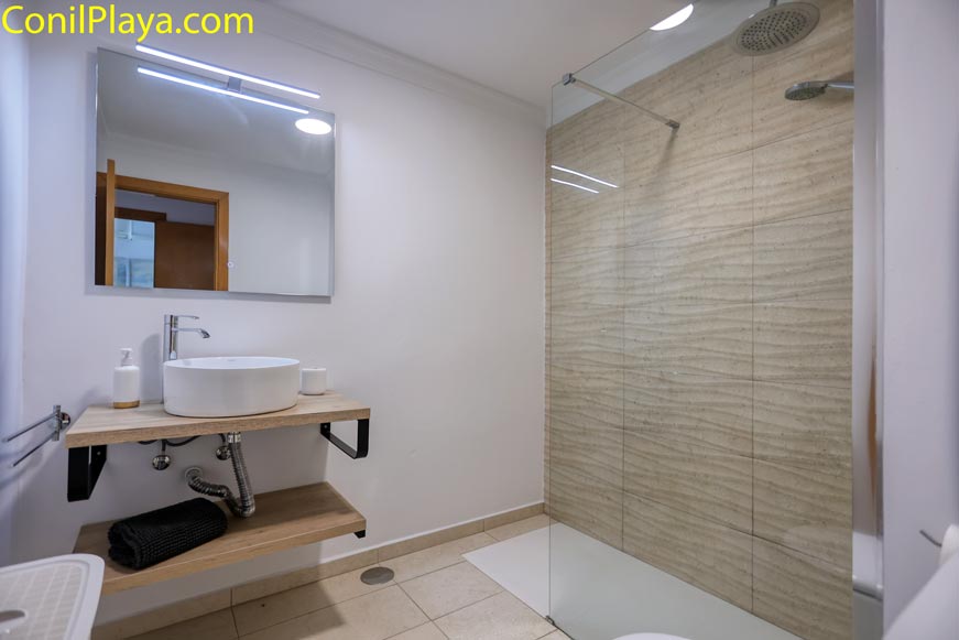 Cuarto de baño moderno con ducha amplia y lavabo sobre encimera