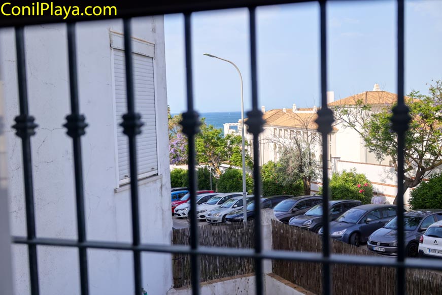 Vista al mar y aparcamiento desde ventana con rejas en primer plano del dormitorio principal
