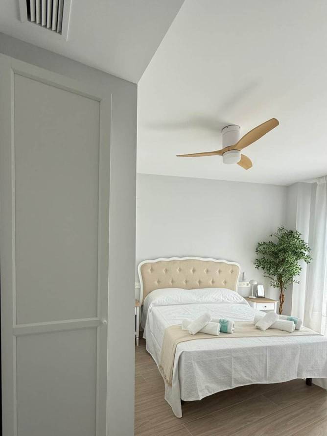 Armario del dormitorio principal con cama doble y ventilador de techo