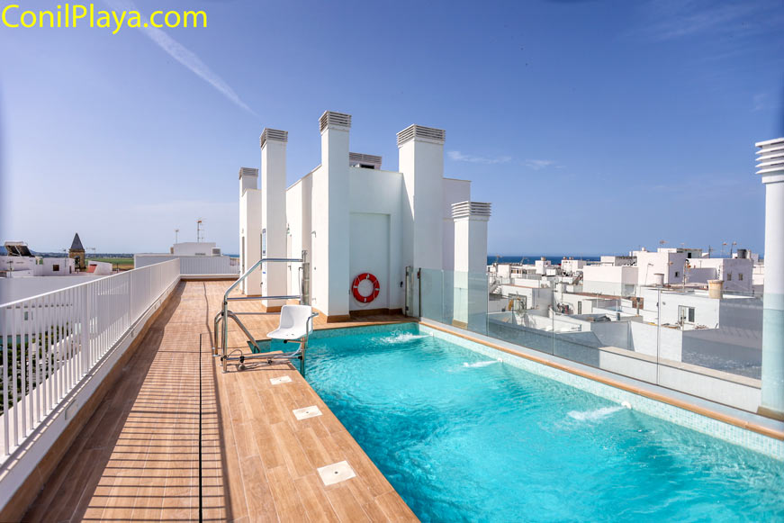 Piscina en azotea con vistas a edificios blancos desde terraza moderna