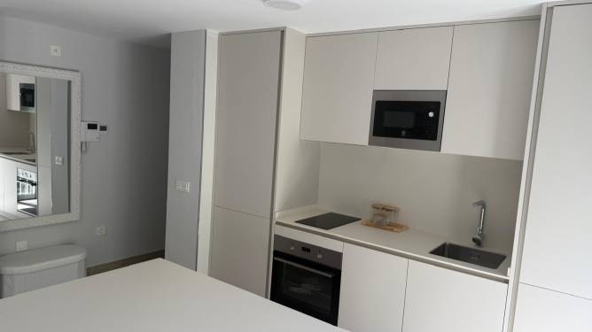 Cocina moderna con muebles blancos vista desde una encimera central