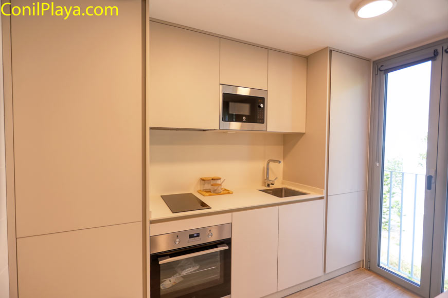 Cocina moderna vista desde la entrada con muebles claros y gran ventanal