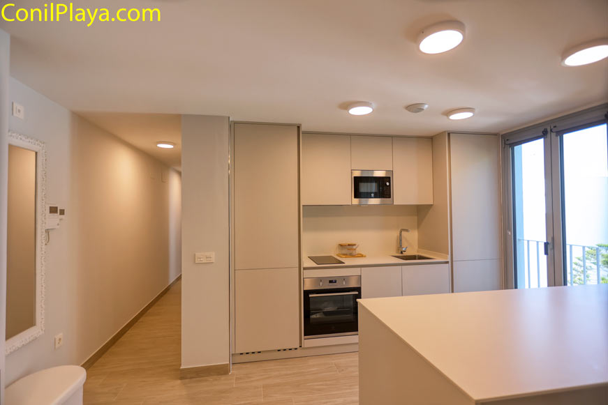 Cocina moderna con muebles blancos vista desde barra lateral