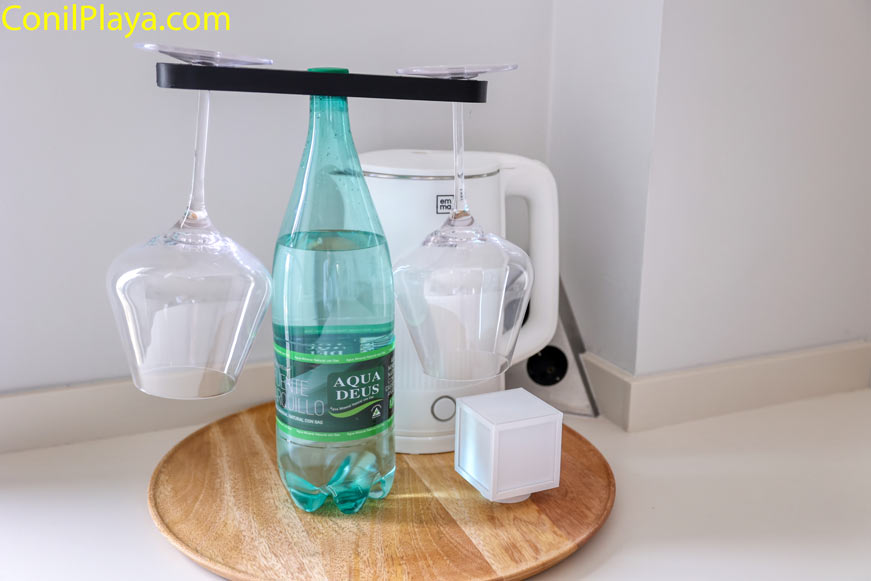 Jarra hervidora de agua emma y botella de agua y copas sobre bandeja en una encimera de cocina moderna