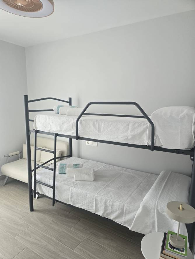 Dormitorio moderno con literas metálicas y decoración minimalista