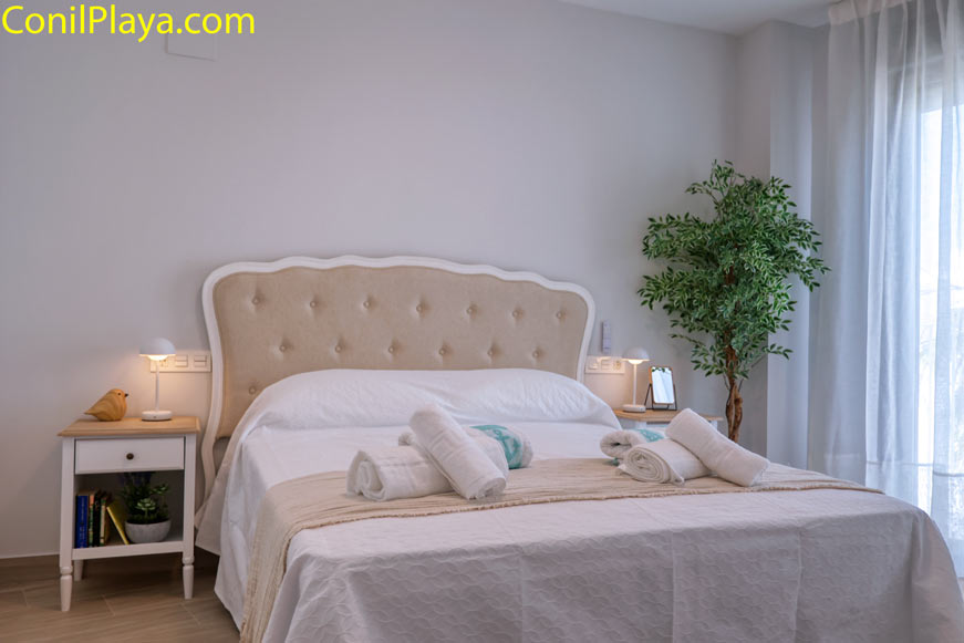 Dormitorio principal con cama doble y detalles decorativos modernos