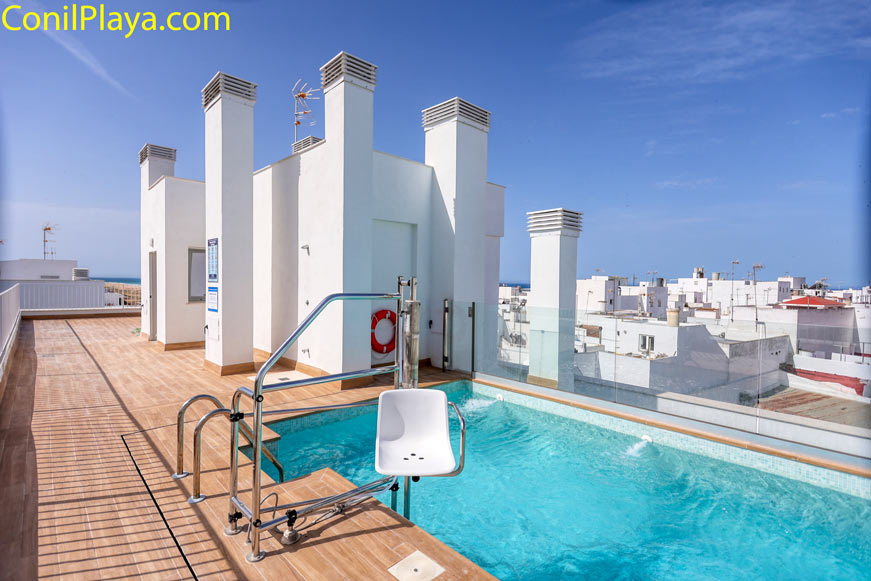 Piscina en azotea de edificio con acceso para minusválidos junto a escaleras de acceso.